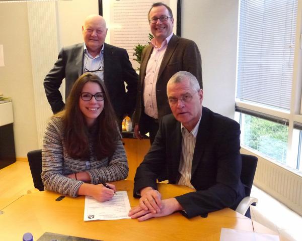 BSV-Manager Peter Prior und Rückraumspielerin Emily Bölk unterzeichnen unter den Augen von Hans-Albert Kusserow und Jan-Peter Frenzel (hinten von links), geschäftsführende Gesellschafter der KFP-Ingenieure, den neuen Ein-Jahres-Vertrag.