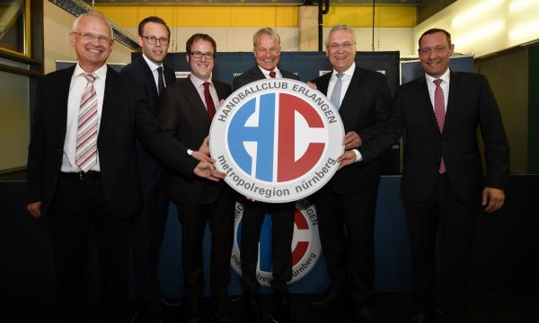 Carsten Bissel - hier 2017 hinter dem HCE-Logo unter anderem mit Bayerns Innenminister Joachim Herrmann