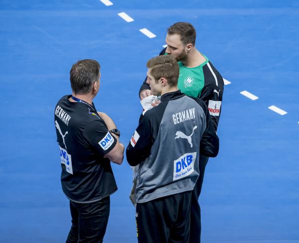Joel Birlehm (mit dem Rücken zum Fotografen) und Andreas Wolff im Gespräch mit Bundestrainer Alfred Gislason. 